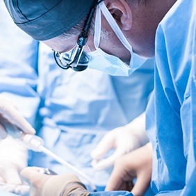 an oral surgeon performing dental implant placement surgery