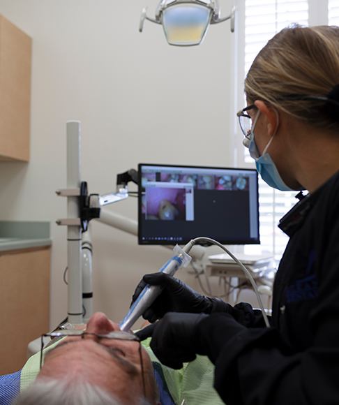 Dental team member performing microscope enhanced dentistry