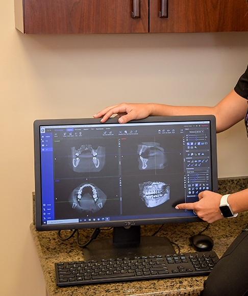 Dentist and patient reviewing digital 2 D and 3 D dental images