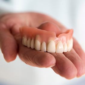a person holding a removable denture in Vero Beach