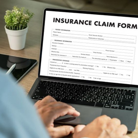 Person filling out insurance claim form on laptop