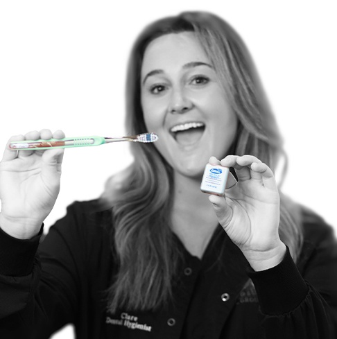 Dental team member in Vero Beach holding toothbrush and dental floss