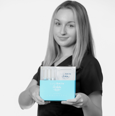 Dental team member holding a teeth whitening kit in Vero Beach