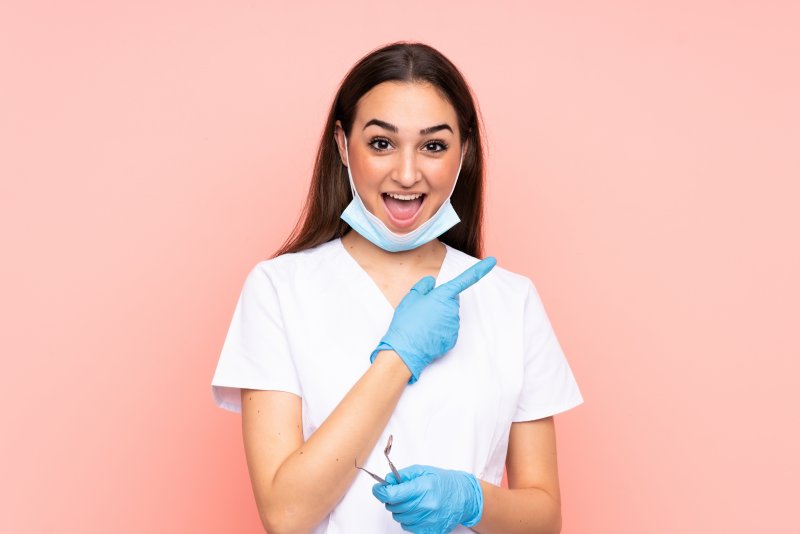 a dentist smiling and pointing