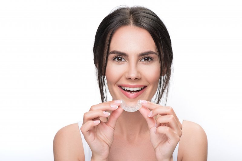 Young woman holding her aligner