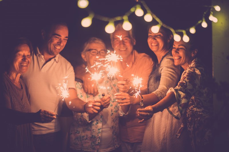 Smiling family holding sparklers
