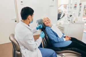 Dentist and patient talking during dental implant consultation 