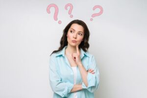 Curious woman with question marks around her head 